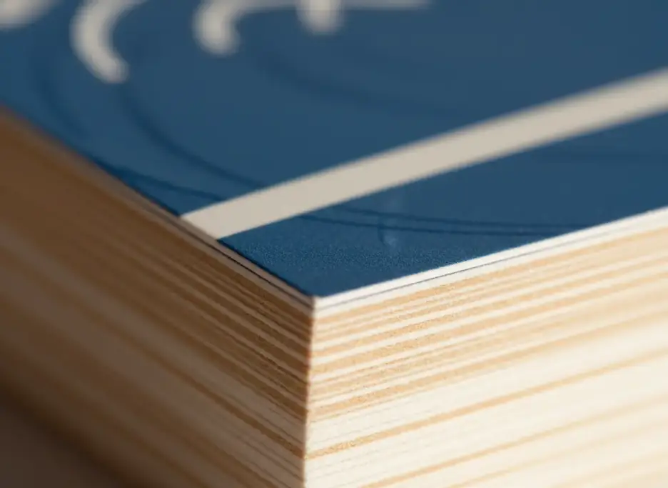 Edge of a squared stack of thick card stock with a glossy coated front